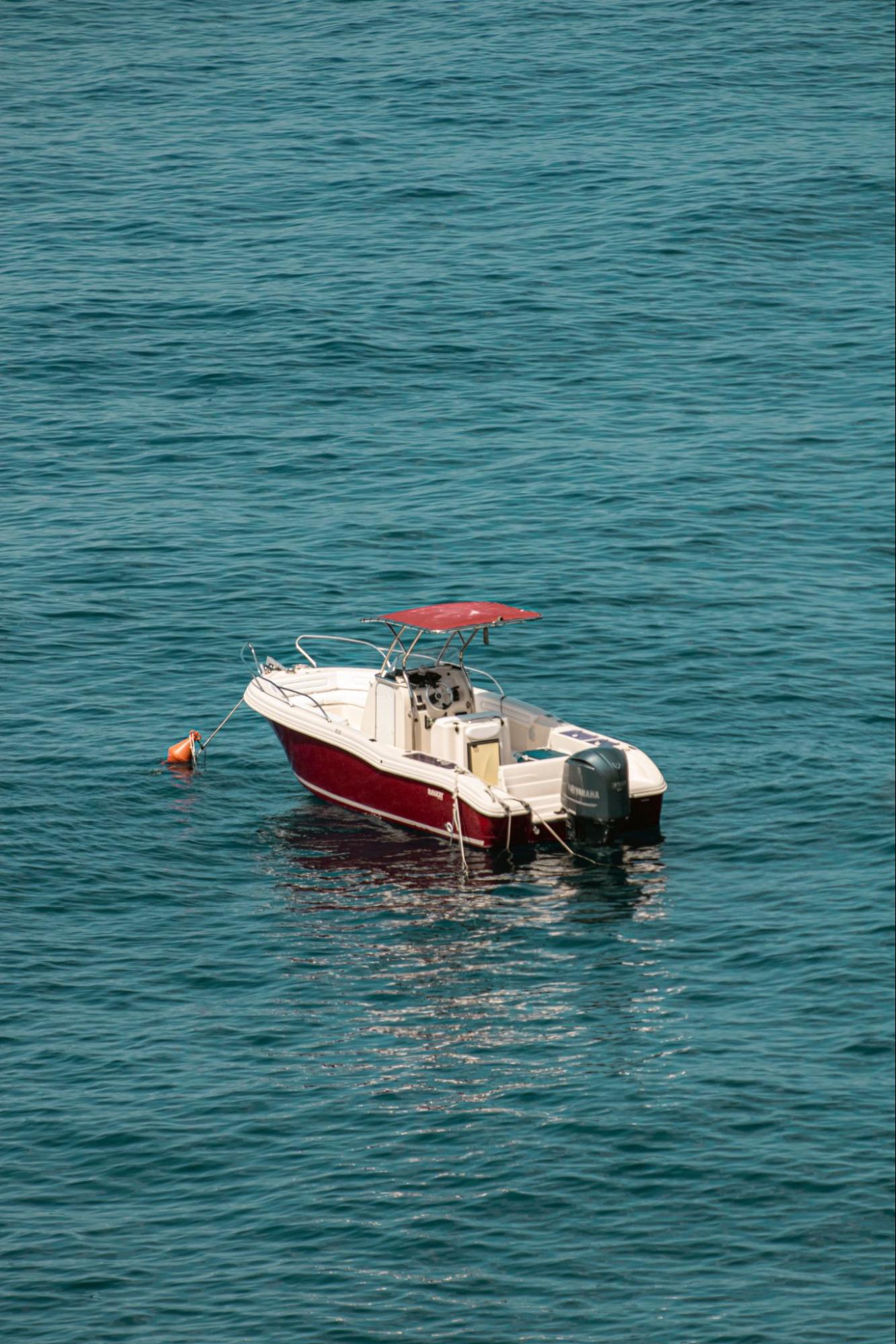 A white center-console fishing boat floating on calm water, equipped with a black Yamaha 40 outboard motor on the stern.