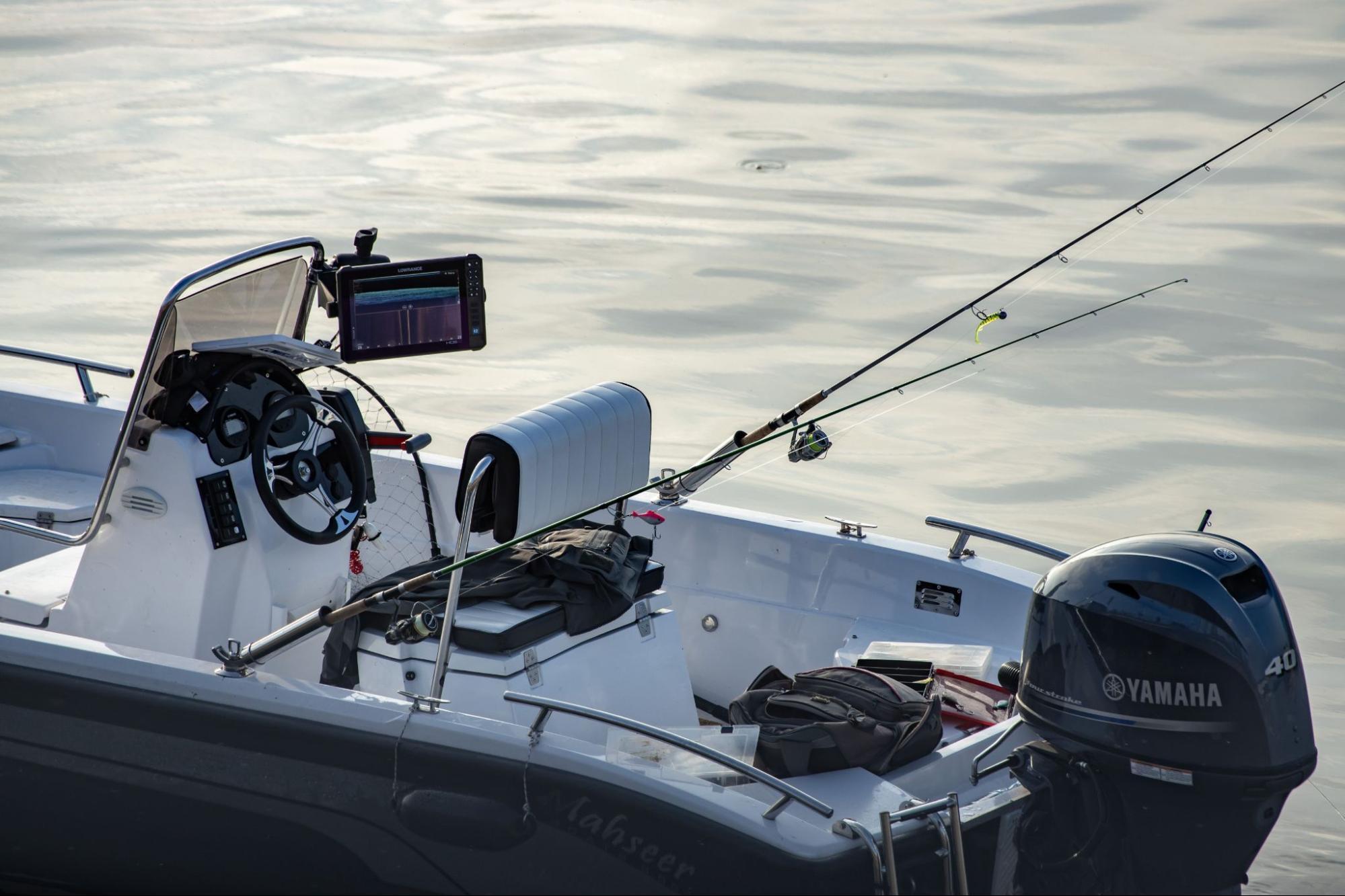 A white center-console fishing boat floating on calm water, equipped with a black Yamaha 40 outboard motor on the stern.