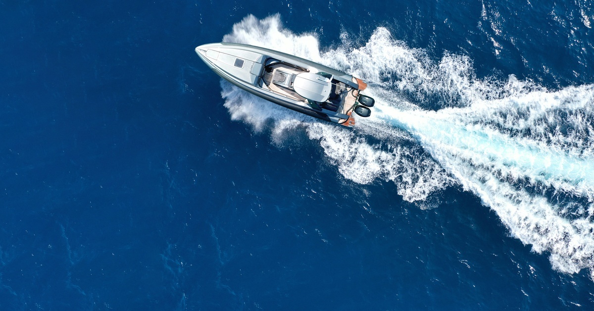 Aerial drone shot of a luxury rigid inflatable speedboat cruising at high speed across the deep blue sea. Aerial drone shot of a luxury rigid inflatable speedboat cruising at high speed across the deep blue sea.