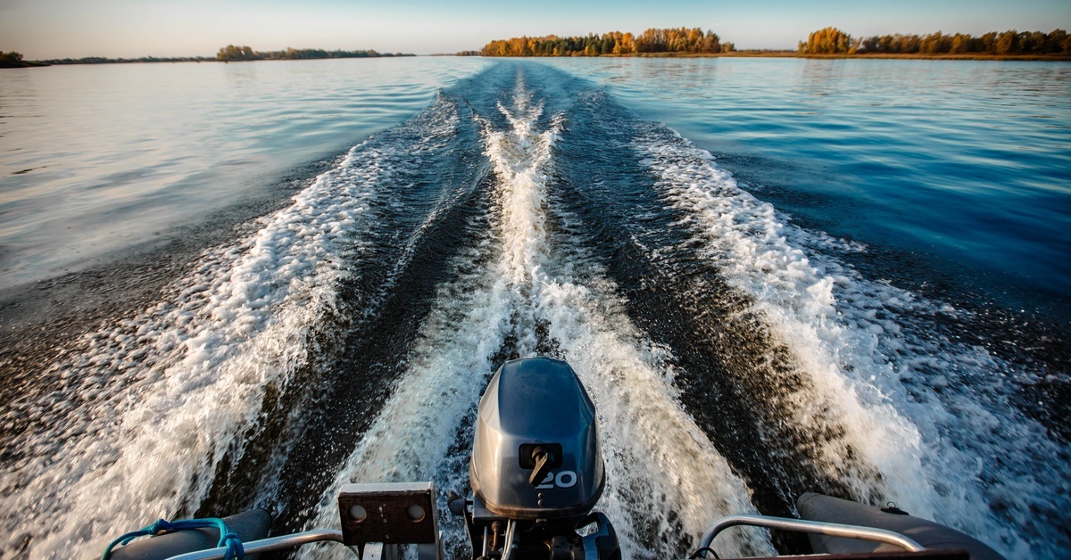 A close-up of the bubble path made by the boat on the large body of water behind the stern of the engine.